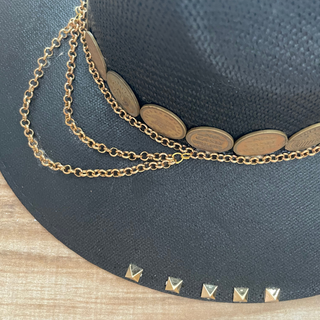 Sombrero negro decorado con cadenas y monedas